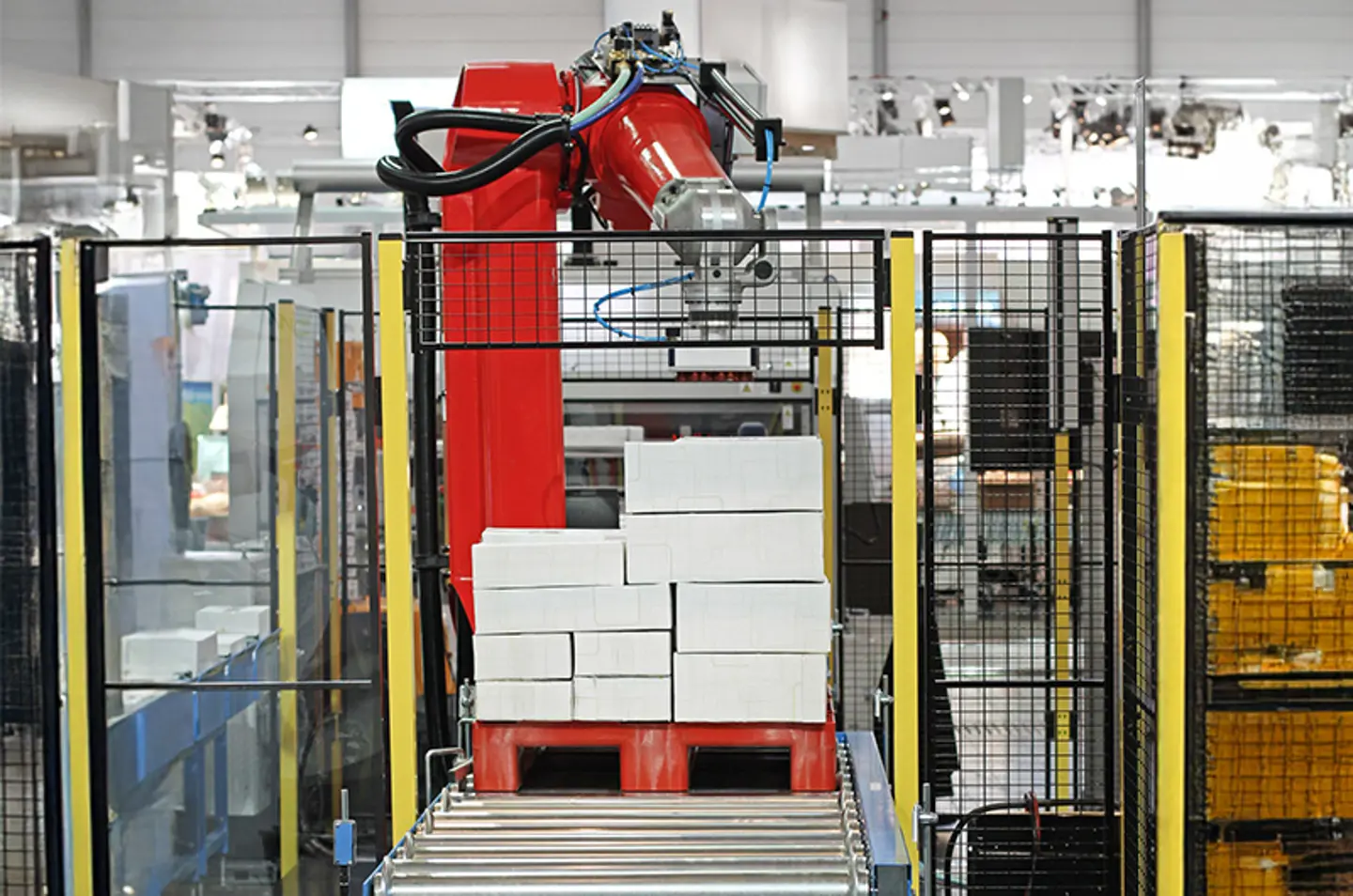 Industriellt transportsystem i en fabrik med säkerhetsbarriärer och varningsremsor på golvet