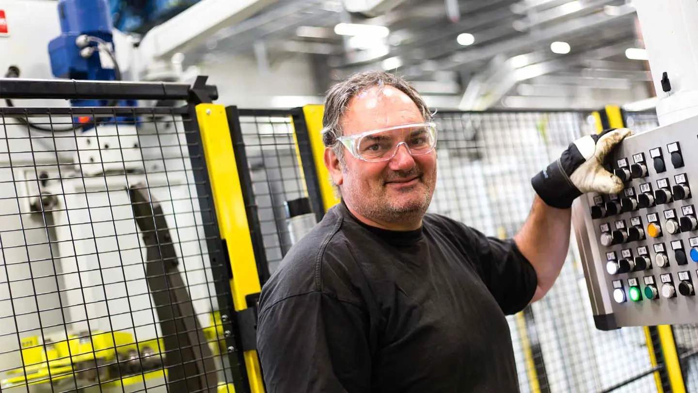 Man manövrerar maskinpanel framför Axelents maskinskydd