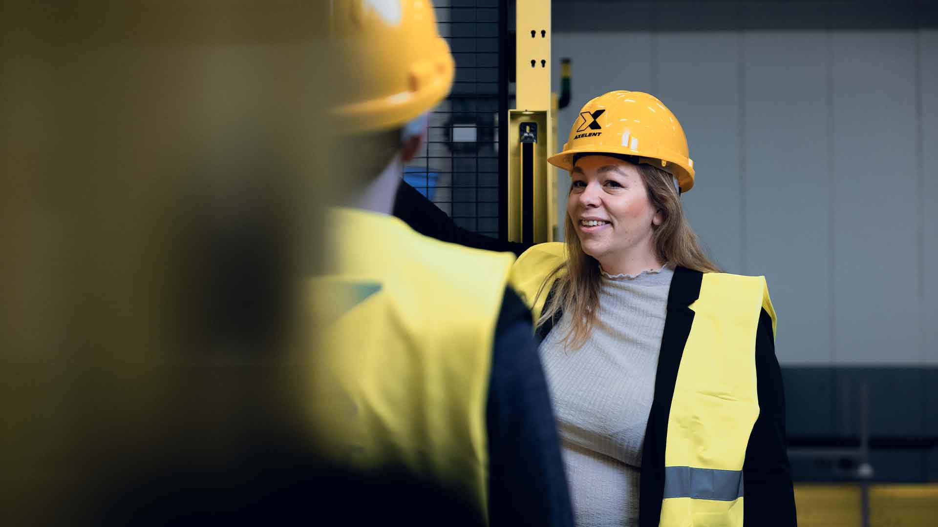 En kvinna pratar och visar hur man hanterar en industrimaskin