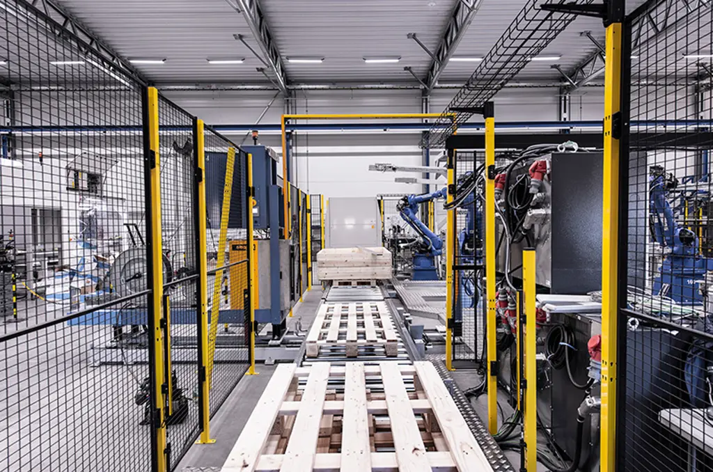Automatiserad palleteringslinje med robotarmar och pallarna i säkerhetszon